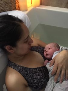 new parent holding baby in tub after waterbirth