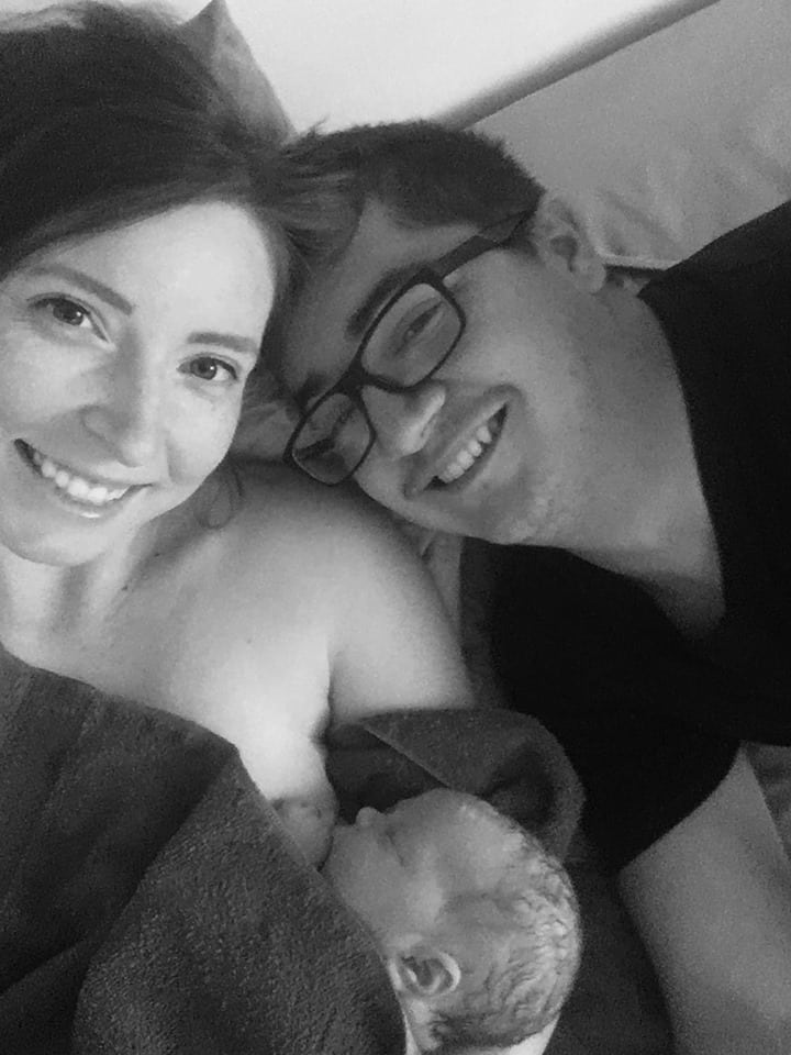 Hypno-mom Brandi laying in bed with her birth partner and newborn.