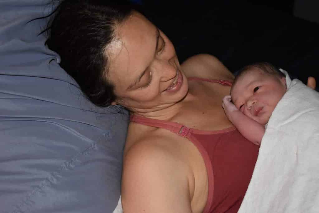 Hypno-mom Valerie with her newborn baby laying on her chest.