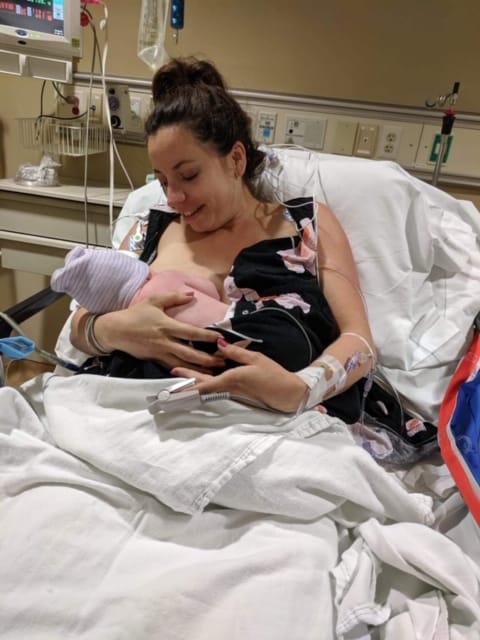 Hypno-mom Anna breastfeeding newborn in a hospital bed.