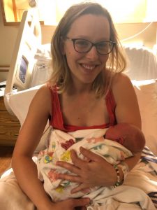 Hypno-mom Joanne sitting on hospital bed holding newborn daughter