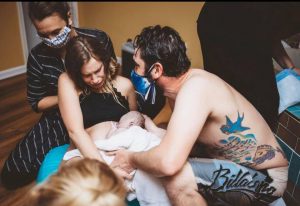 Hypno-mom, partner and birth team just after birth handing newborn to mom Hypnobabies VBAC Birth