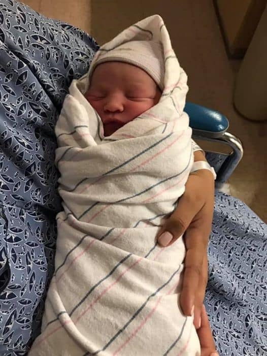 Newborn baby swaddled in hospital blanket