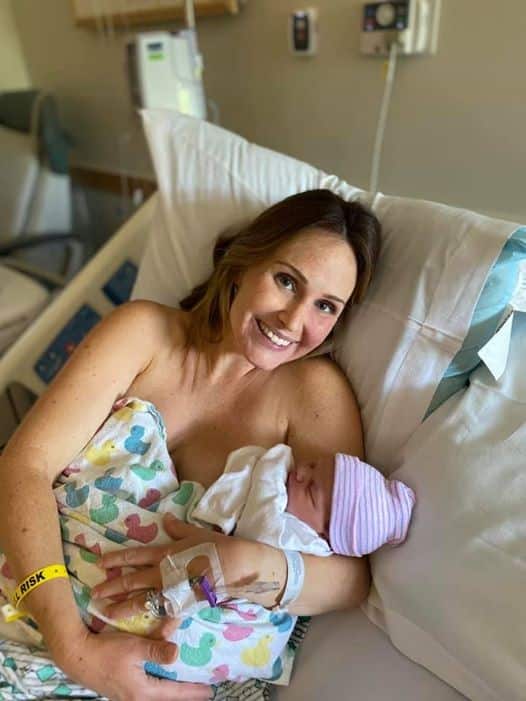 Hypno-mom smiling and holding newborn