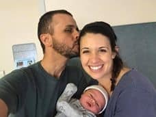 Hypno-mom and partner kissing her cheek while holding newborn