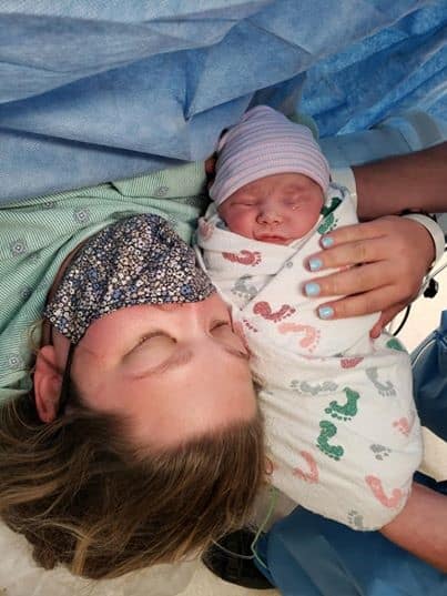 Hypno-mom holding swaddled newborn in OR after c-section