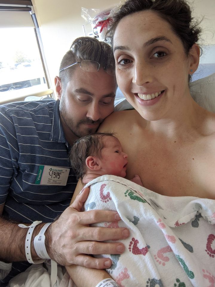 Hypno-mom sitting up in hospital bed with partner and skin to skin with newborn