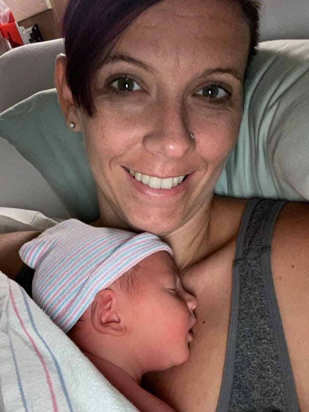 Smiling Hypno mom in hospital bed skin to skin with newborn