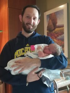 New parent standing and holding newborn
