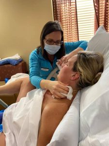 birthing person pushing with doula apply wash cloth to neck