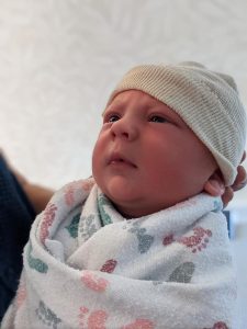 Swaddled newborn baby in a hat