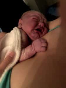 Newborn baby crying while skin to skin