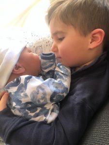 older sibling holding new baby