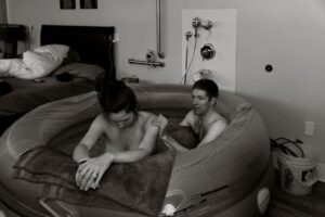 black and white photo of couple in a birthing tub