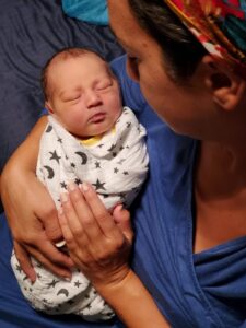 New parent holding swaddled newborn
