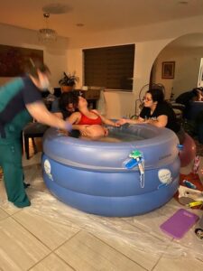 Birthing person being supported in birth tub