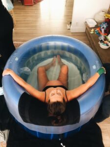 Birthing person leaning back relaxing in birth tub