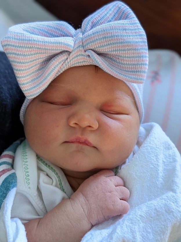 Close up of newborn baby with big bow hat