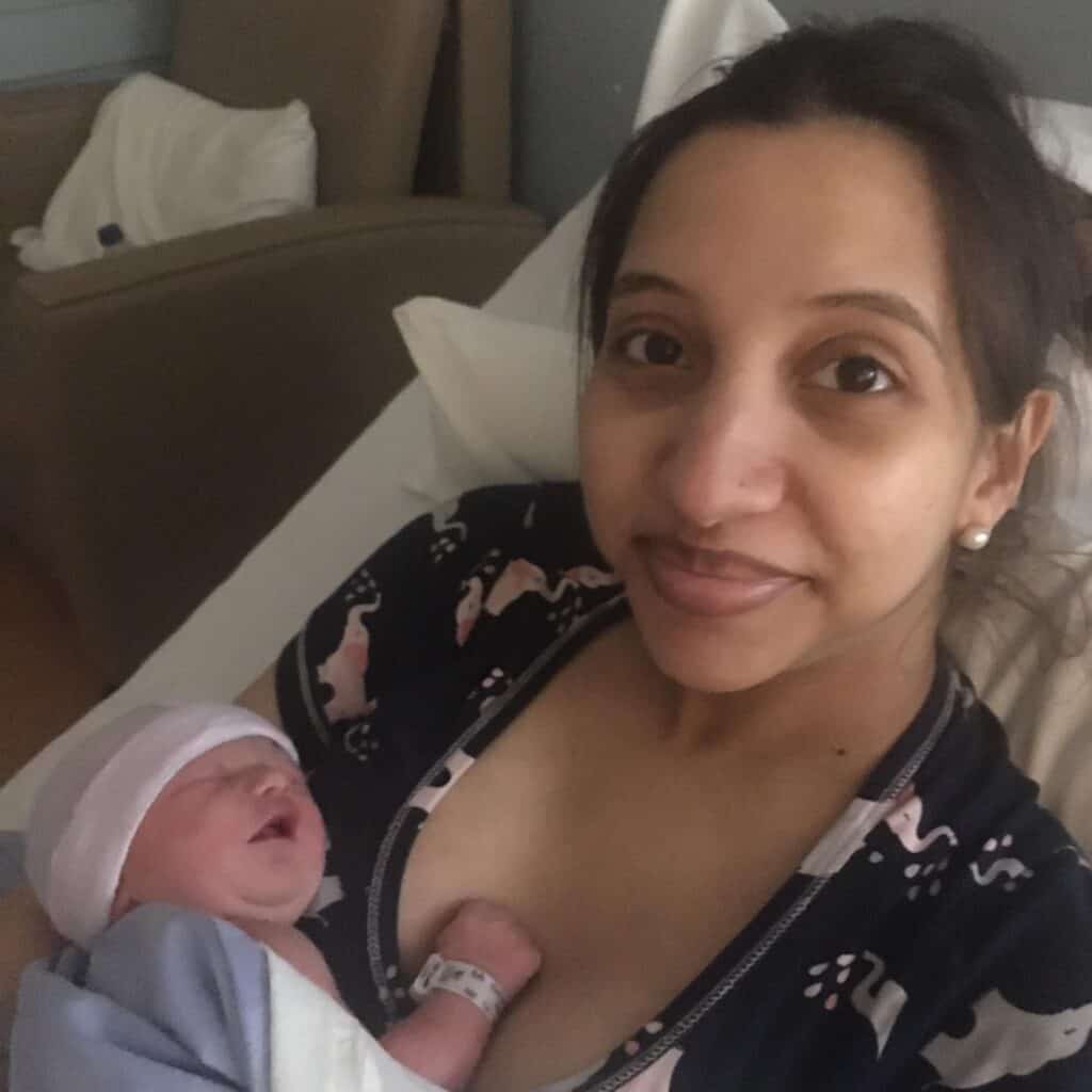 New parent laying in bed holding newborn baby