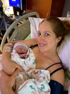 New parent holding newborn baby and smiling