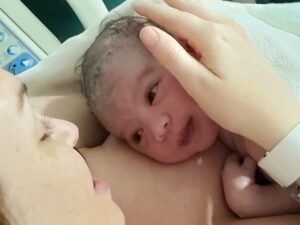 Close up of Hypnobabies student and newborn after positive hospital birth