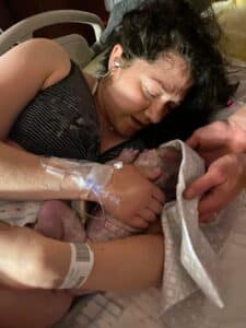 Hypnobabies student holding and drying off newborn baby