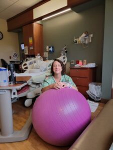 Pregnant person with birth ball smiling during Positive, Easy Induction without Epidural