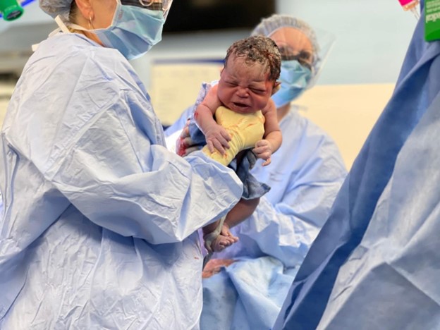 Doctor and newborn during c-section birthing experience