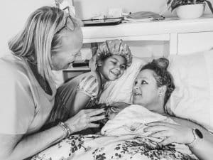 Hypno-student in bed with new baby, mom and daughter after fast and peaceful birth