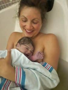 New parent holding newborn after healing Hypnobabies waterbirth
