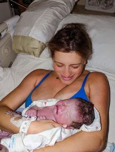 New parent smiling down at newborn baby
