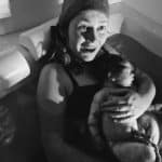 New parent holding baby in tub after birth center waterbirth