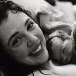 Smiling new parent with newborn baby after Hypnobabies Peaceful Home Birth