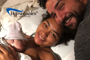 New parents smiling and cuddling newborn baby