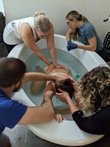 Hypnobabies Student pushing in tub with birth team